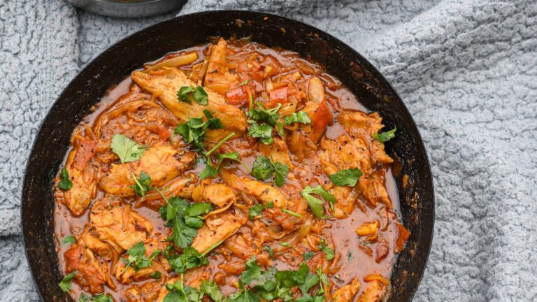 A bowl of vegan chickpea and spinach curry with golden coconut sauce, served with basmati rice
